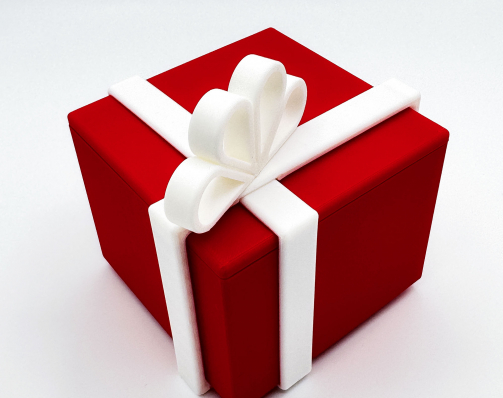 Red 3D printed puzzle gift box with white locking ribbon bow.