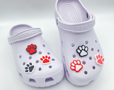 Collection of colorful 3D printed paw print charms on purple shoes.