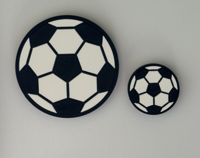 Two flat black and white soccer ball magnets in 28mm and 14mm radius sizes side-by-side.