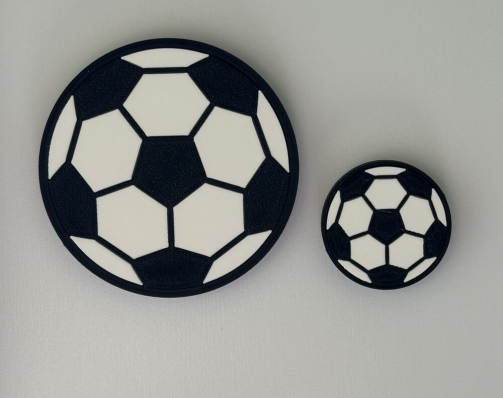 Two flat black and white soccer ball magnets in 28mm and 14mm radius sizes side-by-side.